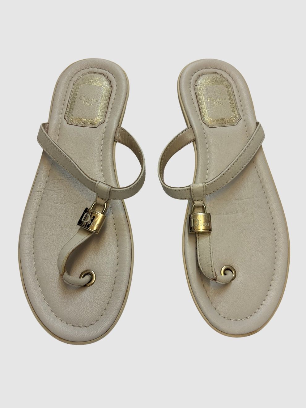 Cremeweiße Leder-Zehensandalen mit goldfarbenem Schlossanhänger von Dior